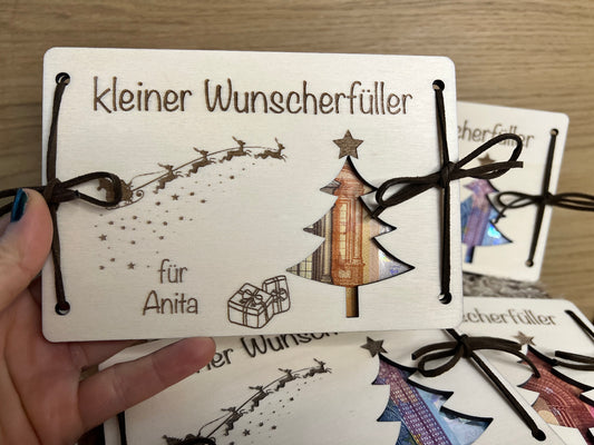 Geldgeschenk kleiner Wunscherfüller für Weihnachten. Personalisiert mit deinem Wunschnamen. Darauf ist ein Weihnachtsbaum ausgeschnitten wodurch das Geld zum vorschein kommt.