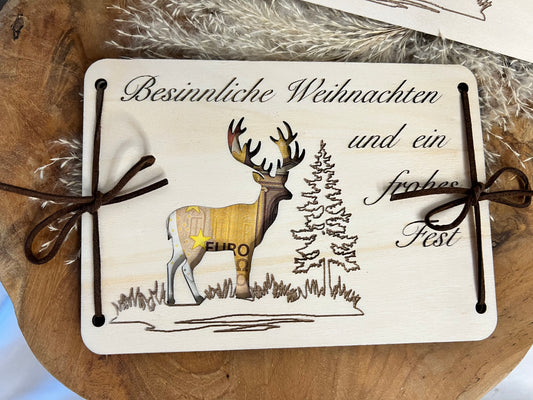 Geldgeschenk für Weihnachten. Mit Spruch Besinnliche Weihnachten. Darauf ist ein Hirschmotiv ausgeschnitten, dadurch kommt das Geld zum vorschein.