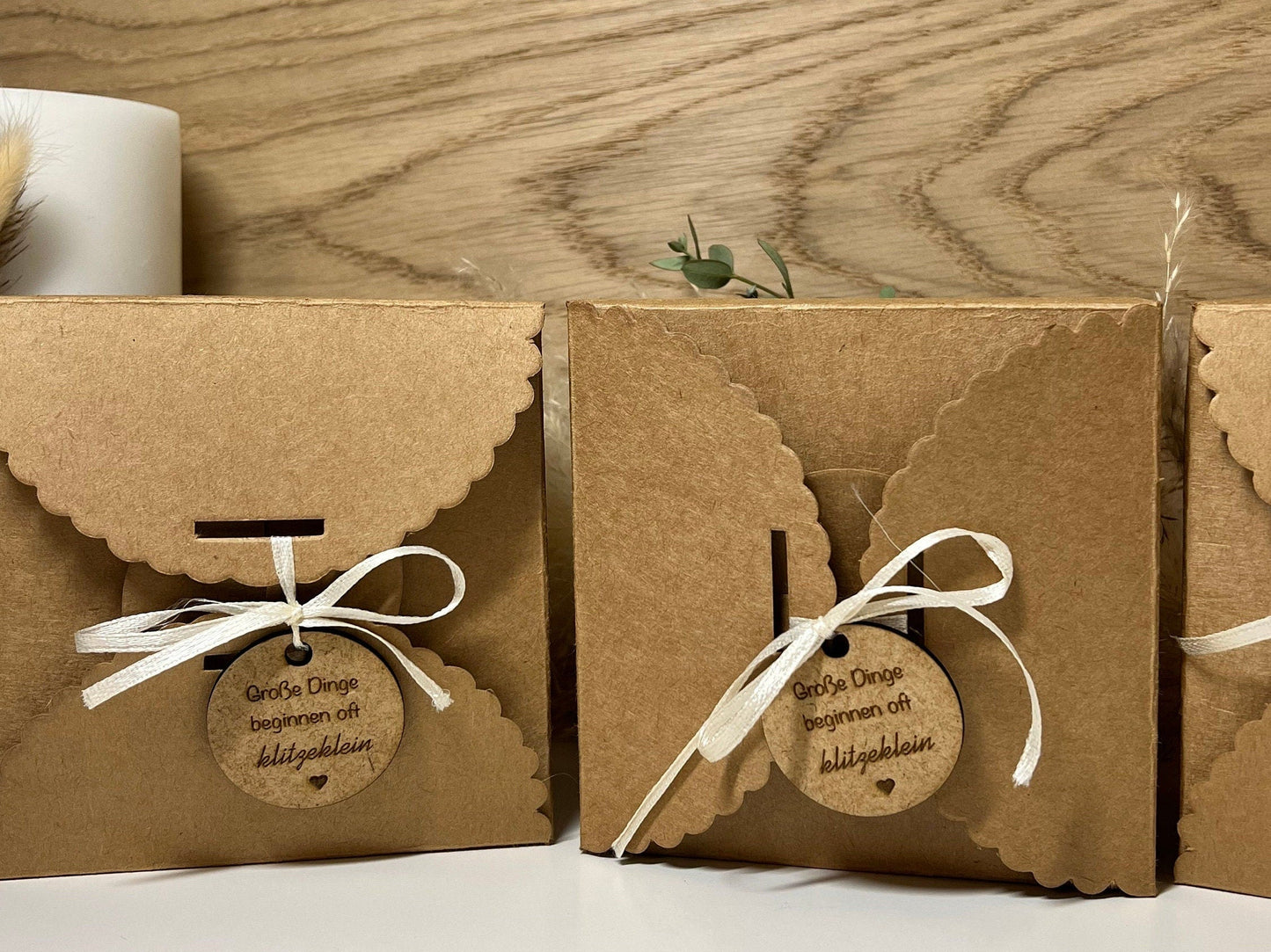Geschenkverpackung mit der Aufschrift: Große Dinge beginnen oft klitzeklein. Darin befindet sich ein graviertes Holzherz mit der Überraschung du wirst Papa.