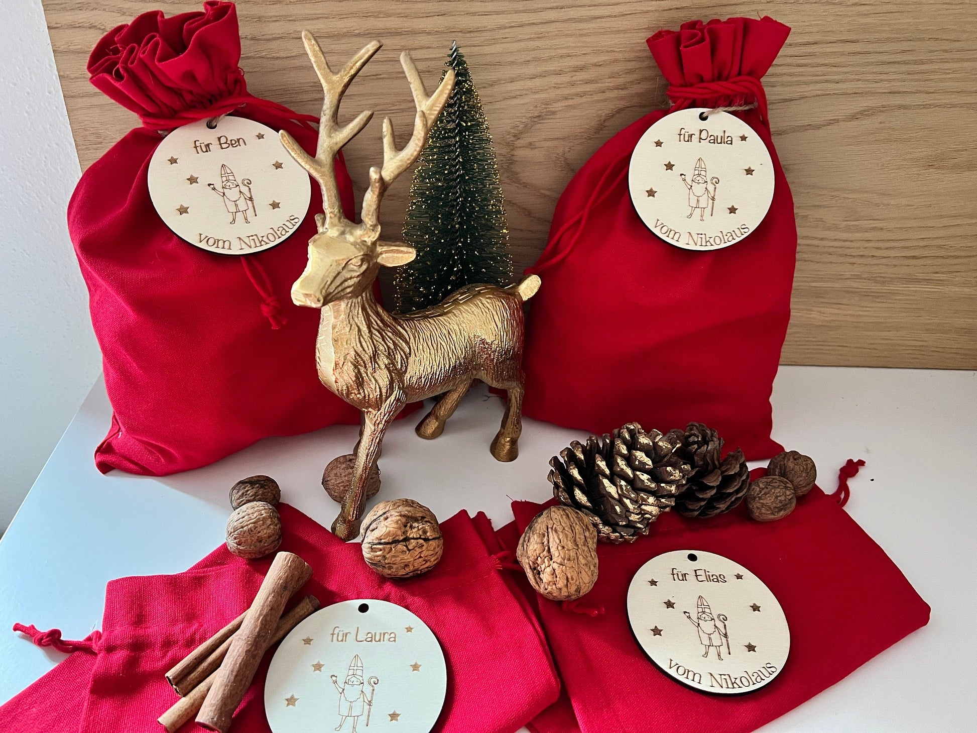 Rotes Nikolaussäckchen, mit personalisierter Holzplatte. Graviert mit dem Wunschnamen und Nikolaus Motiv.