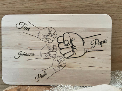 Frühstücksbrettchen personalisiert für Papa. Auf dem Bild ist eine Hand mit Papa draufgraviert, dann Kinderhände mit den Namen der Kinder.