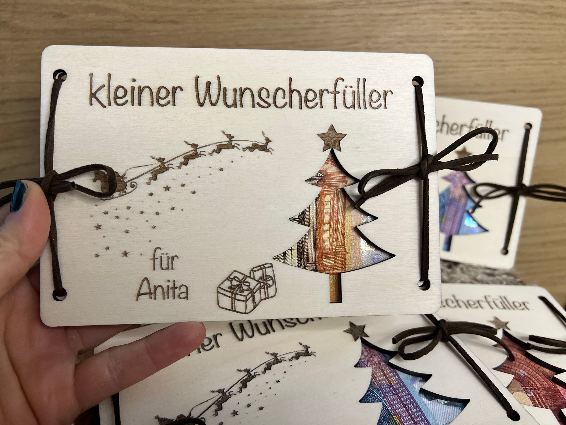 Geldgeschenk kleiner Wunscherfüller für Weihnachten. Personalisiert mit deinem Wunschnamen. Darauf ist ein Weihnachtsbaum ausgeschnitten wodurch das Geld zum vorschein kommt.