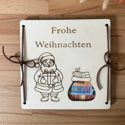 Personalisiertes Geldgeschenk zu Weihnachten aus Holz mit Weihnachtsmann, Wunschname und Geldschein im Geldsack