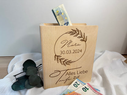 Tolle Geschenkidee zur Taufe. Gravierte Spardose aus Holz in Buchform. In der Größe 18x15 cm. Darauf wird auch der Name und das Datum des Tauflings graviert.